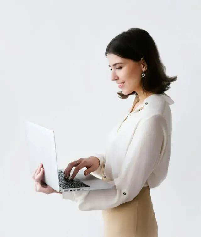 woman standing and holding a laptop