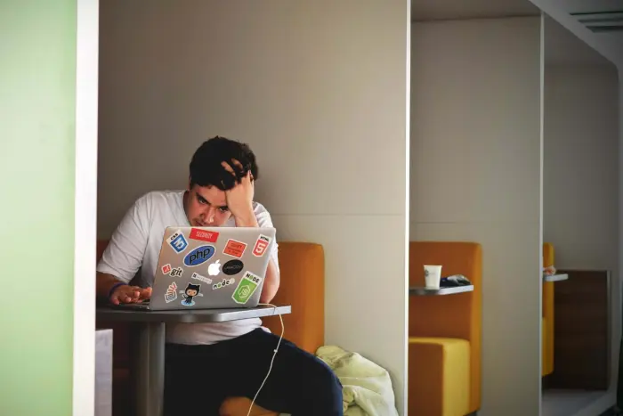 man looking frustratedly at laptop
